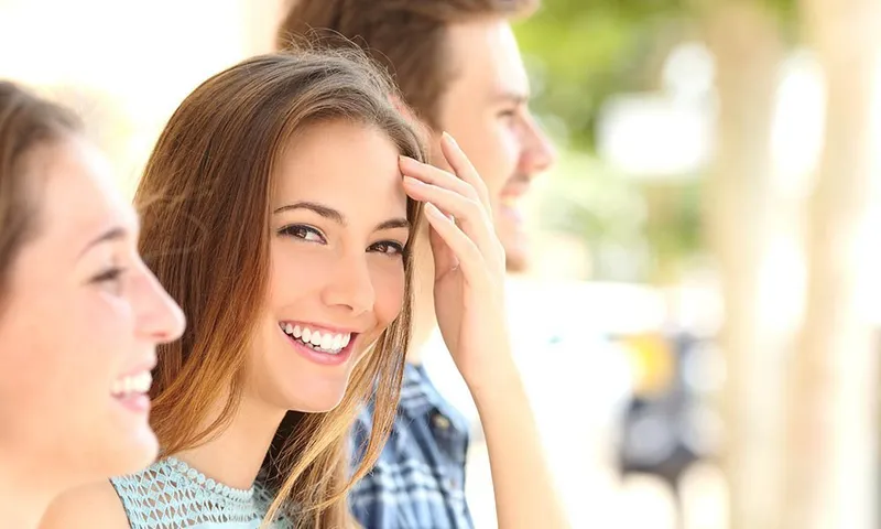 Happy patient showcasing the results of refreshed and replaced composite tooth bonding.